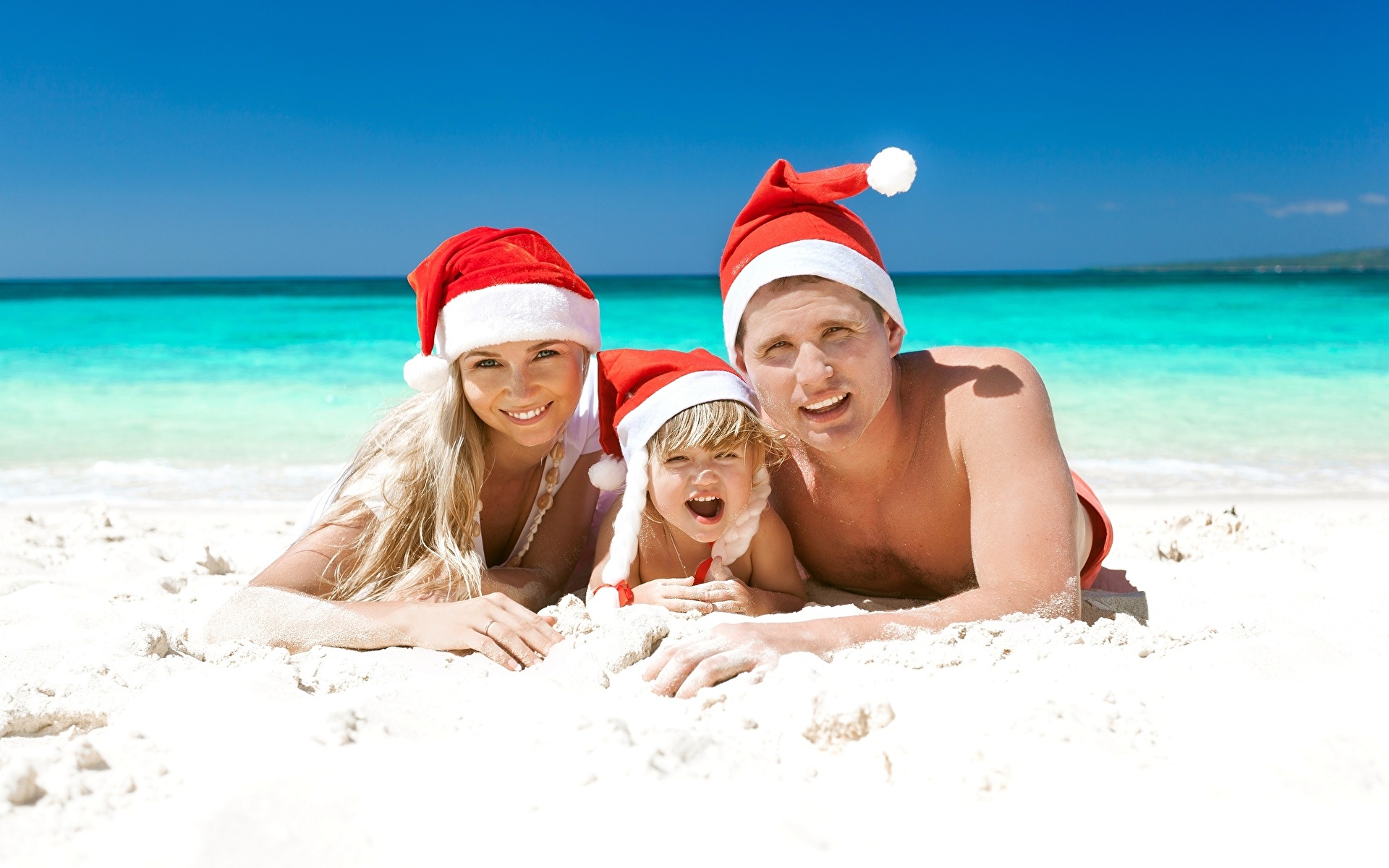 Фотографии ребёнок Новый год Мужчины пляжа молодые женщины Море шапка Семья песке втроем 1920x1200 Дети Рождество мужчина Пляж пляже пляжи девушка Девушки молодая женщина Шапки в шапке песка Песок три Трое 3
