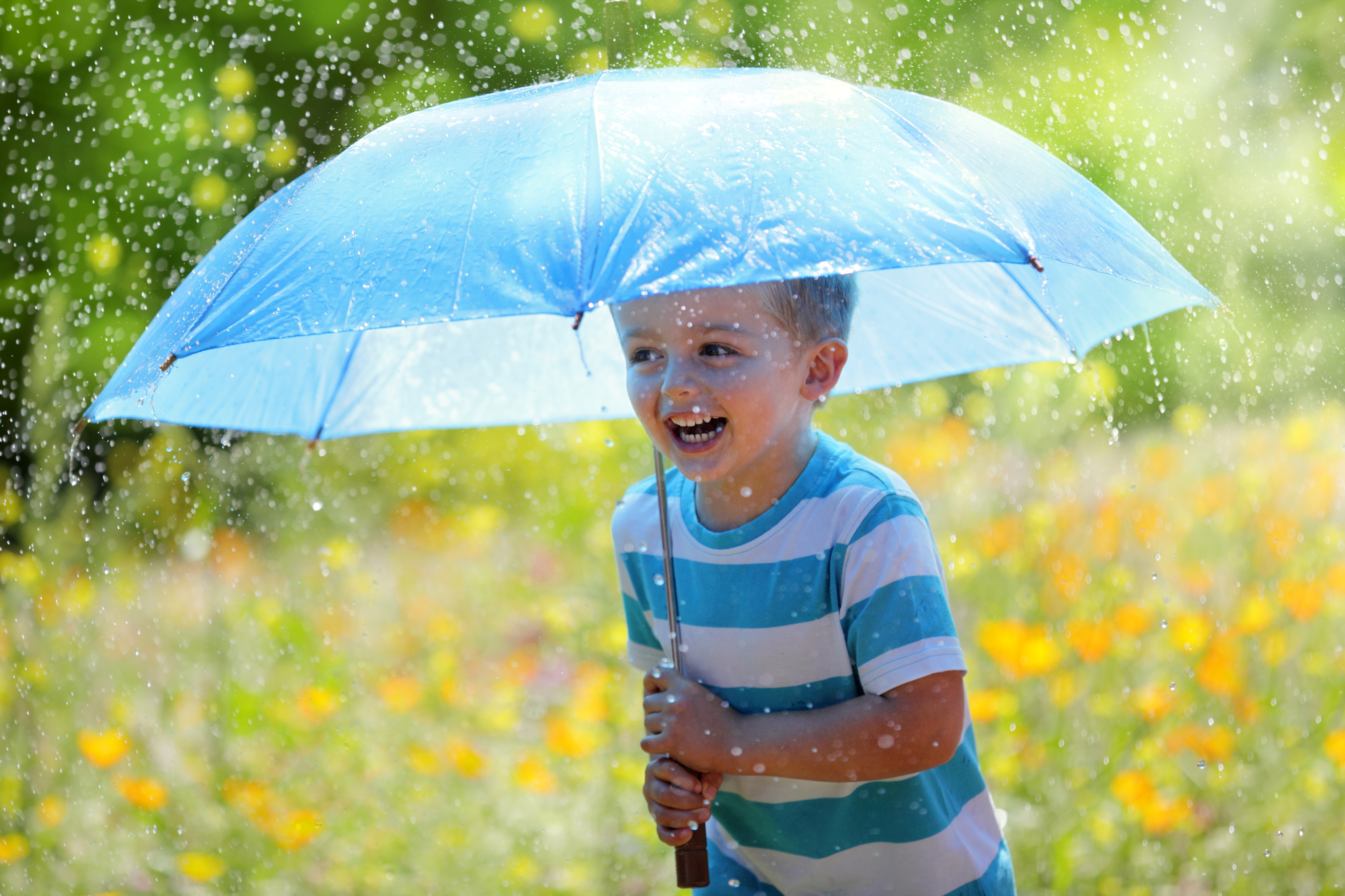 Мальчик с зонтиком под дождем